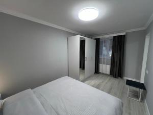 a white bedroom with a bed and a window at Hotel in Yerevan in Yerevan