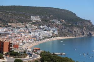 - une vue sur une ville avec une plage et des bâtiments dans l'établissement Just Sezimbra- Modern Apt 3 Min from Beach, à Sesimbra