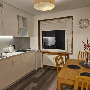 a kitchen and dining room with a table and a window at Buto nuoma Dariaus ir Girėno gatvėje in Telšiai