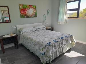 a bedroom with a bed and two tables and a window at Zebra Crossing in Bushmans River Village