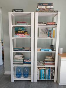 a white book shelf filled with books at Zebra Crossing in Bushmans River Village