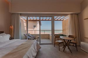 a bedroom with a bed and a table and chairs at Pousada Aysú in Japaratinga