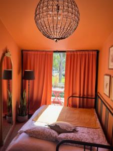 a bedroom with a bed with orange walls and a chandelier at Jardim de Cascais in Cascais
