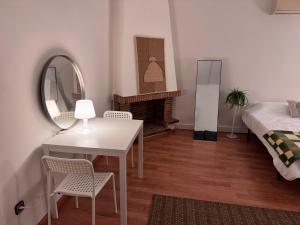 1 dormitorio con mesa, cama y espejo en Estudio Las Rozas de Madrid, en Las Rozas de Madrid