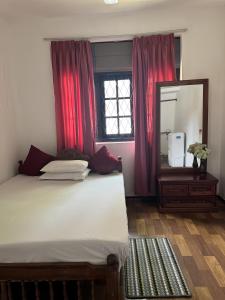 a bedroom with a large bed and a mirror at The Colombo House in Battaramulla
