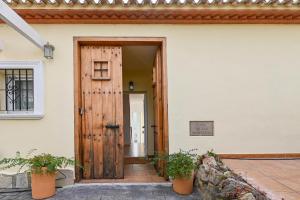 een open deur van een huis met twee potplanten bij Casa de las Montañas in Parcent +36 foto's