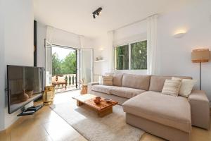 een woonkamer met een bank en een flatscreen-tv bij Casa de las Montañas in Parcent