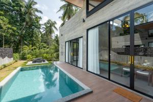 a swimming pool in the backyard of a house with glass walls at Balance Village - exclusive villa with facility offered a full sense of privacy and resort style swimming pool in Ko Phangan