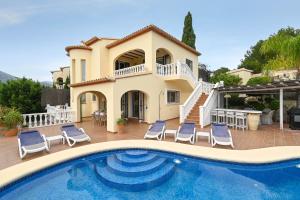 a villa with a swimming pool and a house at Casa de las Montañas in Parcent