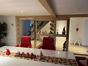 een woonkamer met 2 rode stoelen en een trap bij Les Villas du Ried in Daubensand +49 foto's