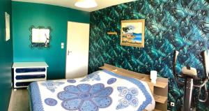 a bedroom with a bed and a green wall at La petite cauchoise in Bacqueville-en-Caux +4 photos