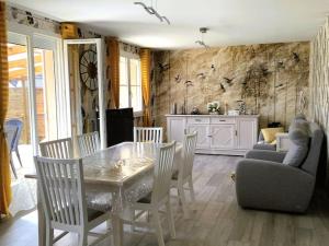a dining room with a table and chairs and a kitchen at La petite cauchoise in Bacqueville-en-Caux
