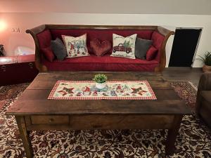 een woonkamer met een rode bank met kussens bij Les Villas du Ried in Daubensand