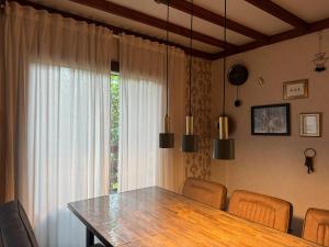 a dining room table with chairs and a large window at La Clairiere - Erezee- 3 bedroom chalet in Érezée
