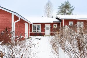 een rood huis met een hond in de sneeuw bij Santas Duplex II in Rovaniemi