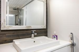 een witte wastafel in een badkamer met een spiegel bij Santas Duplex II in Rovaniemi +4 foto's