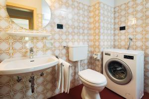 ein Badezimmer mit Toilette, Waschbecken und Waschmaschine in der Unterkunft MiraOdle Apartments in Villnöß + 57 Fotos