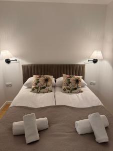 Una cama con dos almohadas blancas encima. en Apartamenty Dąbrówka Cieplice Zdrój, en Jelenia Góra