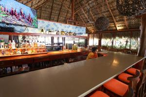 a woman sitting at a bar in a restaurant at Nicawaves in Popoyo