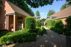 Le Mirage De Watermolen Kasterlee في كاستيرلي: منزل من الطوب مع سياج وممر