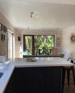 Refugio Ecos del Bosque في بورتو فاراس: مطبخ مع طاولة ونافذة كبيرة +8 صور