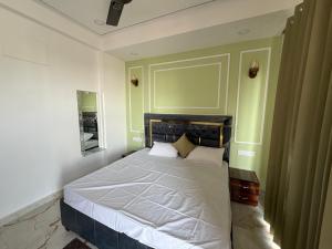 a bedroom with a large bed with white sheets at The White Lotus Homestay in Dharmsala