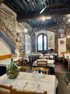 ヴェルナッツァにあるホテル ジャンニ フランジのテーブルと椅子(白いテーブルクロス付)が備わるレストラン