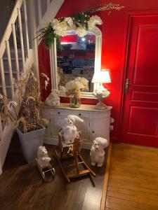 Chez Patou في لافال: غرفة ذات جدار أحمر اللون، وبها مرآة وحيوانات على كرسي +43 صورة