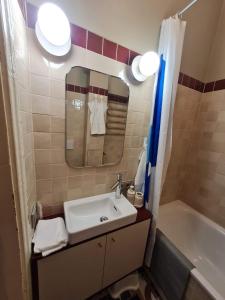 ein Badezimmer mit Waschbecken, Spiegel und Badewanne in der Unterkunft K15 History Apartments in Vilnius