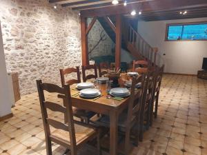 a dining room with a wooden table and chairs at Gîte "EN VALROMEY" au pied du Grand Colombier in Munet +21 photos