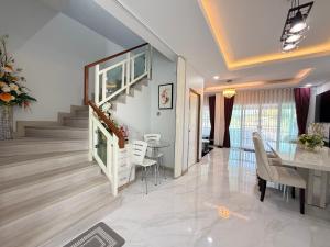 Un comedor y una sala de estar con mesa y sillas. en Home Hug You, en Chiang Mai