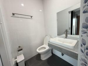 Un baño blanco con inodoro y lavabo. en Home Hug You, en Chiang Mai 25 fotos más