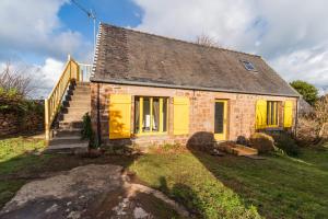 ein altes Steinhaus mit gelben Türen und Treppen in der Unterkunft Le Refuge de la Clarté, draps et serviettes inclus in Perros-Guirec