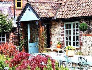 a brick house with a table and chairs in a garden at Escape the Ordinary in Piddletrenthide