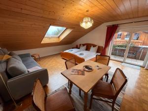 a living room with a couch and a bed and a table at Villa am Goldbach in Bad Aibling