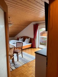 een kamer met een bed, een tafel en stoelen bij Villa am Goldbach in Bad Aibling