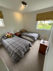 Cómodo Depto en bosques de la candelaria في ألغاروبو: غرفة نوم بها سريرين ونافذة