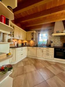 Una cocina grande con gabinetes blancos y una ventana. en LaDolceVita im Tiroler Holzhaus, en Bad Elster