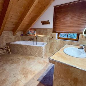 Un baño grande con bañera y lavabo. en LaDolceVita im Tiroler Holzhaus, en Bad Elster