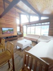 サン・フランシスコ・ド・スルにあるCasa de Praiaのベッド2台、ソファ、テレビが備わる客室です。