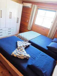 サン・フランシスコ・ド・スルにあるCasa de Praiaの窓のある部屋にベッドが2つある +2枚の写真