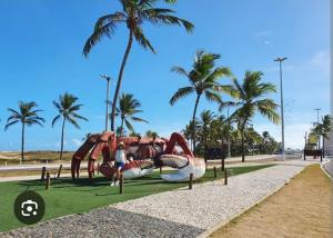 una persona parada frente a un patio de juegos en Pousada na Orla, Atalaia, en Aracaju