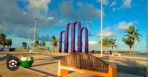 Un parque con un banco y un grupo de tablas de surf. en Pousada na Orla, Atalaia, en Aracaju