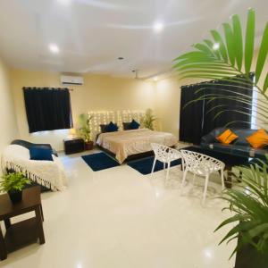 a bedroom with a bed and a couch and chairs at Hotel Velvet Stay Near DLF Cyber City in Hyderabad