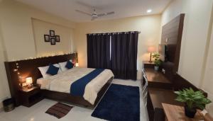 a bedroom with a large bed with a blue rug at Hotel Velvet Stay Near DLF Cyber City in Hyderabad +3 photos