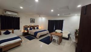 a bedroom with two beds and a table and chairs at Hotel Velvet Stay Near DLF Cyber City in Hyderabad