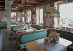 un restaurante con cabinas verdes, mesas y ventanas en Landgasthof Franz Josef, en Strasswalchen