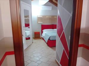 Casa Happy - La mansarda del sorriso con parcheggio privato a Valcorrente في بيلباسو: غرفة نوم صغيرة مع سرير ومرآة