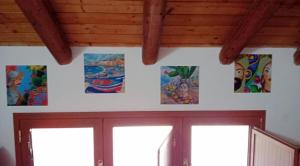 Casa Happy - La mansarda del sorriso con parcheggio privato a Valcorrente في بيلباسو: مجموعة من اللوحات على جدار الغرفة +62 صورة