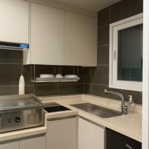 釜山にあるBeaver Stay, Bosuの白いキャビネットとシンクのあるキッチン +3枚の写真
